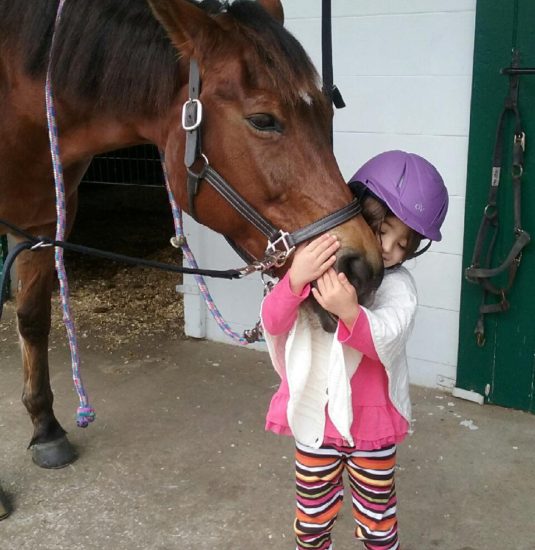 loving image of disabled girl hugging a horse
